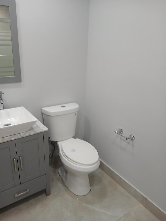 bathroom featuring toilet, tile patterned flooring, and vanity