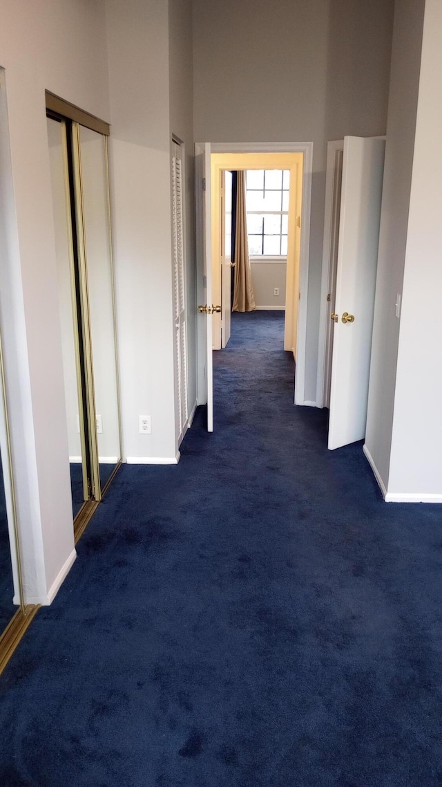 corridor with dark colored carpet