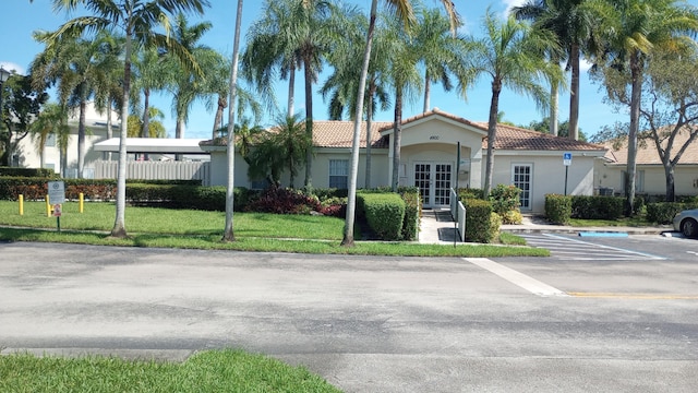 view of front of house with french doors and a front lawn