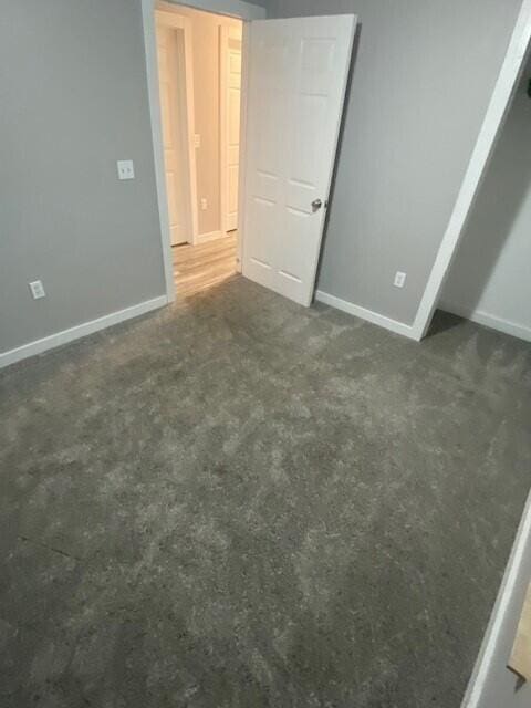 unfurnished bedroom with dark colored carpet