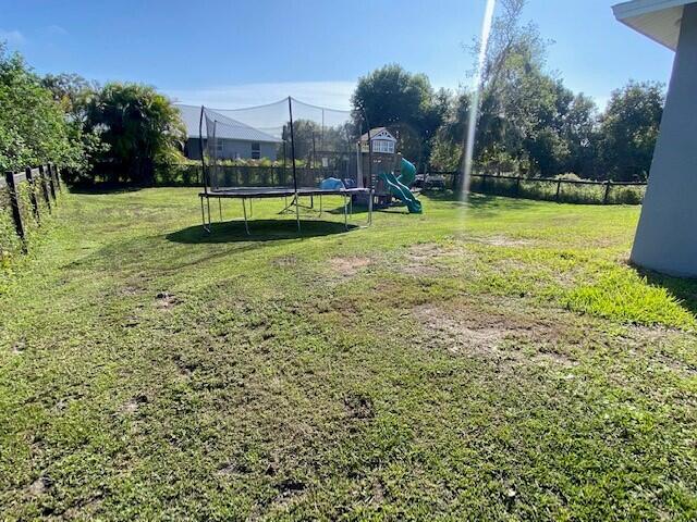 view of yard with a playground and a trampoline