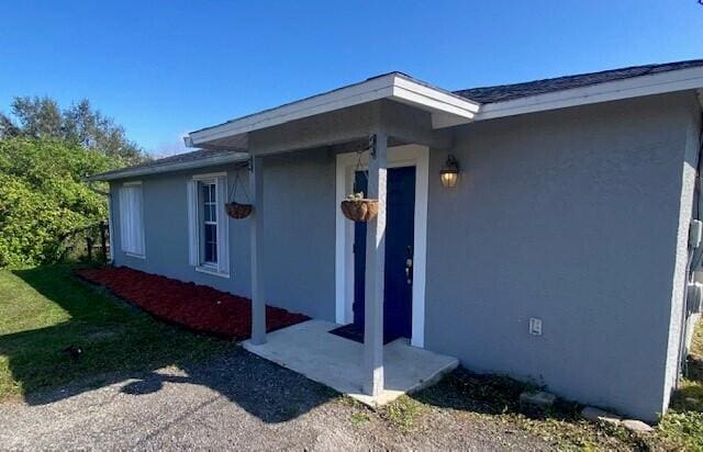 view of exterior entry featuring a yard