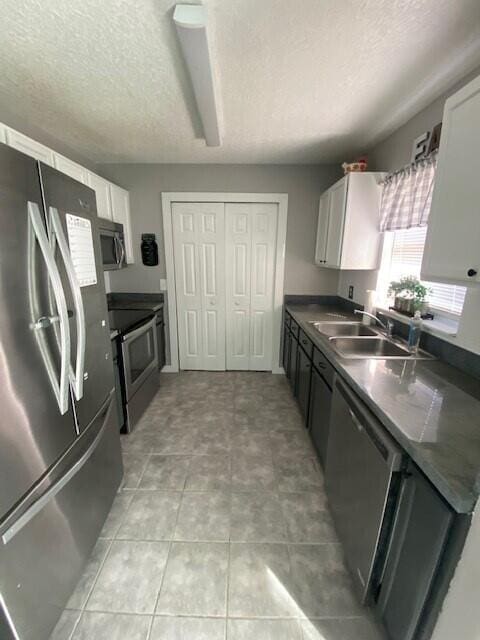 kitchen featuring white cabinets, sink, appliances with stainless steel finishes, and a textured ceiling