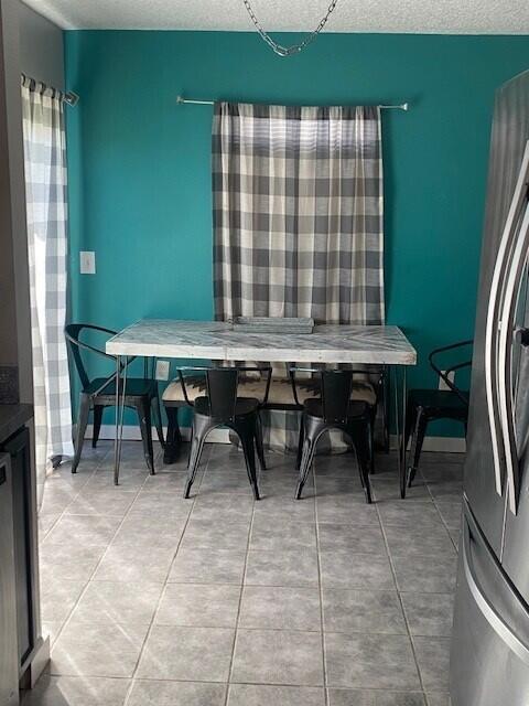 dining space with tile patterned flooring and a textured ceiling