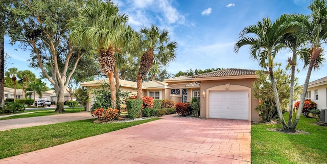 view of front of property with a front lawn, decorative driveway, an attached garage, and stucco siding