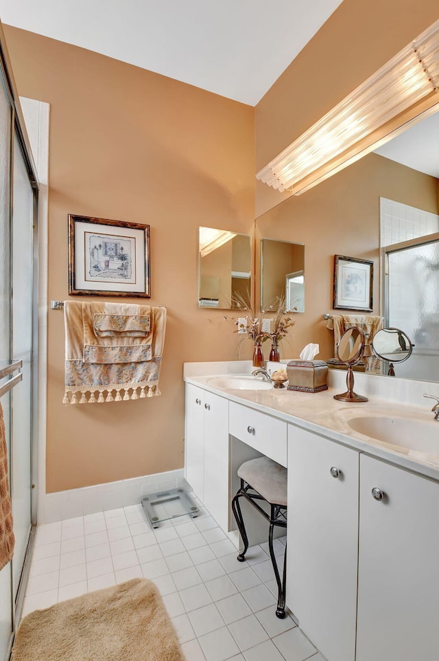 full bath featuring tile patterned floors, a sink, a shower stall, and double vanity