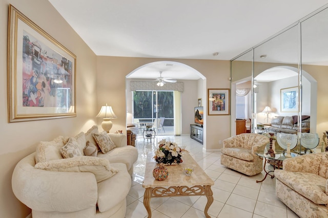 tiled living room featuring arched walkways and ceiling fan