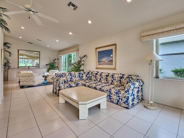 tiled living room featuring ceiling fan and lofted ceiling