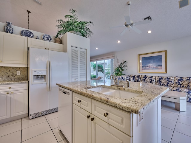 kitchen featuring a center island with sink, white appliances, sink, and light tile patterned floors