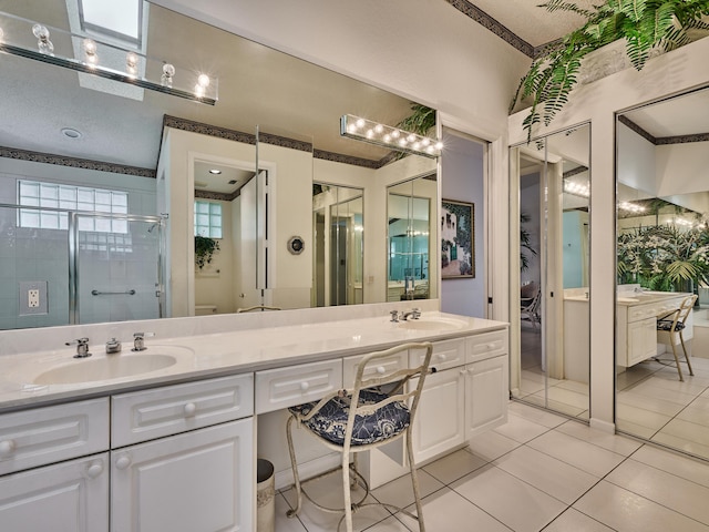 bathroom featuring tile patterned flooring, vanity, and walk in shower