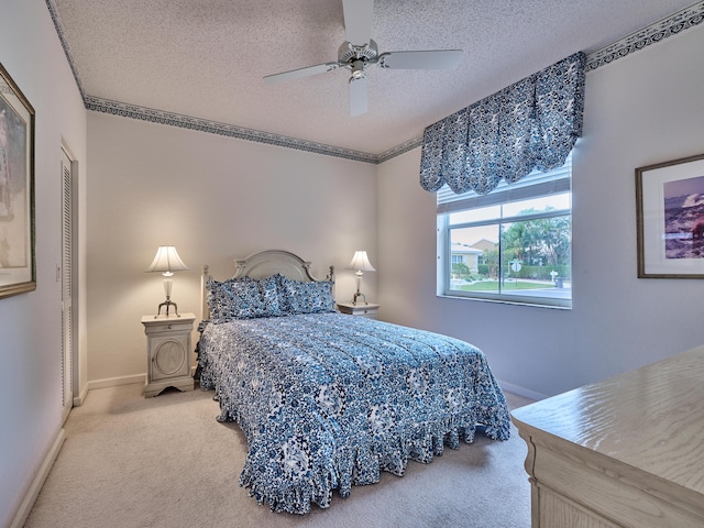 carpeted bedroom featuring ceiling fan, a closet, and a textured ceiling