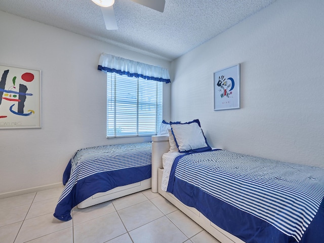 bedroom with tile patterned floors, ceiling fan, and a textured ceiling