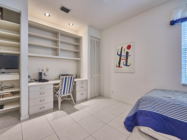 tiled bedroom featuring a textured ceiling