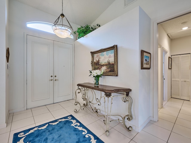 tiled foyer with lofted ceiling