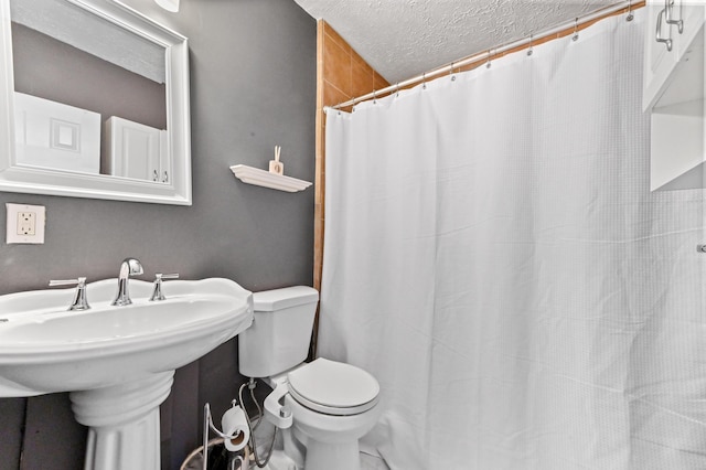 bathroom with sink, a textured ceiling, toilet, and walk in shower