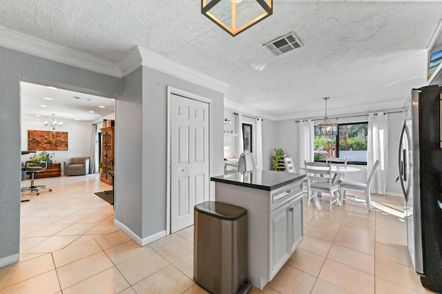 kitchen featuring an inviting chandelier, decorative light fixtures, light tile patterned flooring, and stainless steel refrigerator