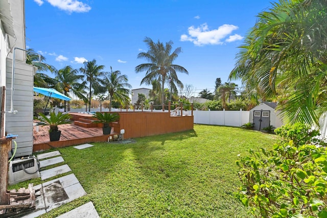 view of yard with a shed and a pool side deck