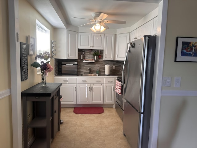 kitchen featuring tasteful backsplash, white cabinets, sink, and stainless steel appliances