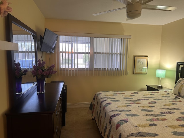 tiled bedroom featuring ceiling fan