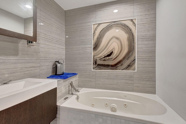 bathroom featuring vanity and tiled tub