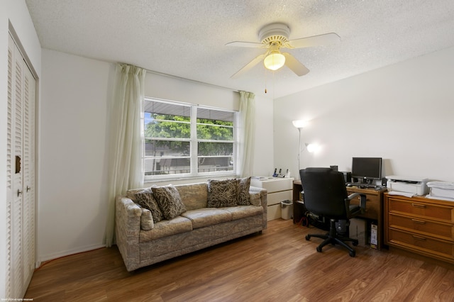 home office featuring ceiling fan, wood-type flooring, and a textured ceiling