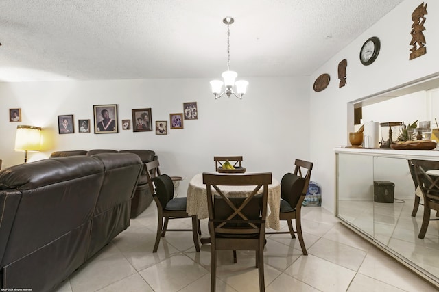 tiled dining area with a notable chandelier and a textured ceiling