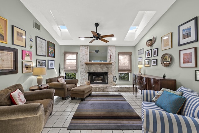 tiled living room featuring ceiling fan, a large fireplace, and lofted ceiling