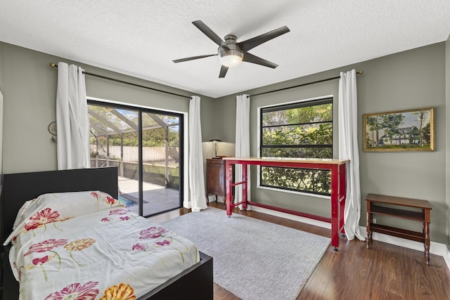 bedroom with a textured ceiling, access to exterior, ceiling fan, and dark hardwood / wood-style floors