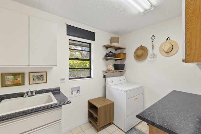 clothes washing area with cabinets, a textured ceiling, sink, light tile patterned floors, and washer / clothes dryer