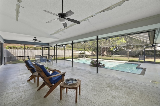 view of patio with ceiling fan, a fenced in pool, and glass enclosure