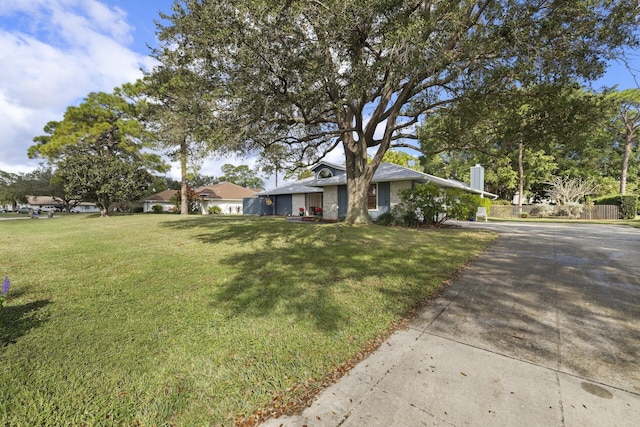 ranch-style home featuring a front lawn and fence