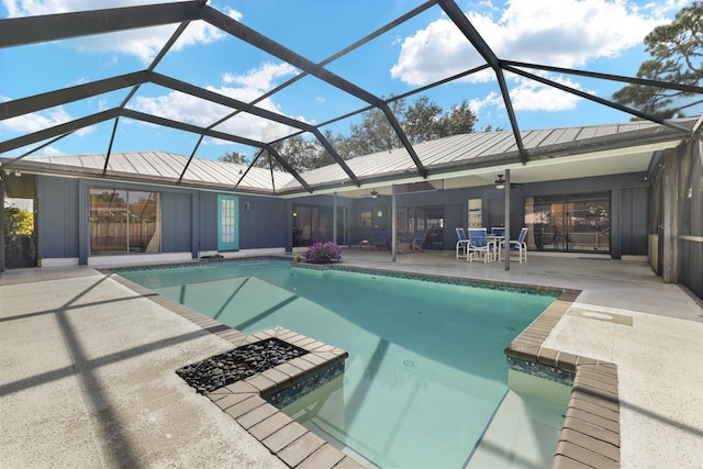 view of pool featuring a patio, glass enclosure, and ceiling fan