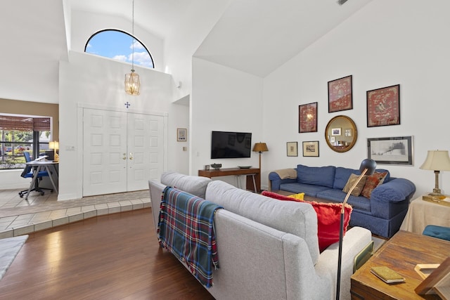 living room with a chandelier, dark hardwood / wood-style floors, and high vaulted ceiling