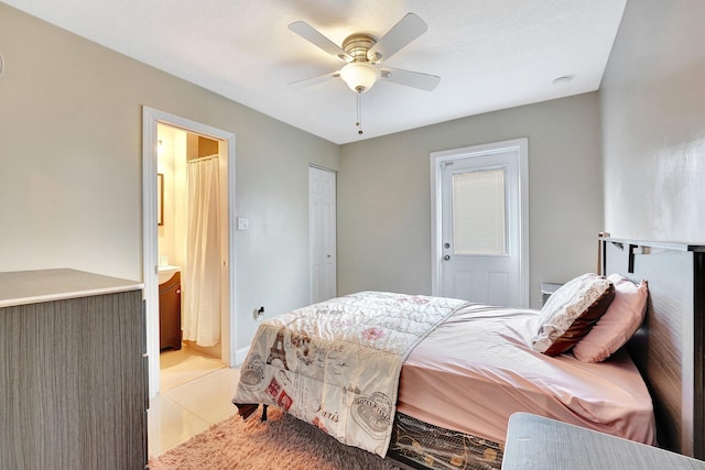 bedroom featuring ceiling fan, a closet, light tile patterned floors, and ensuite bathroom