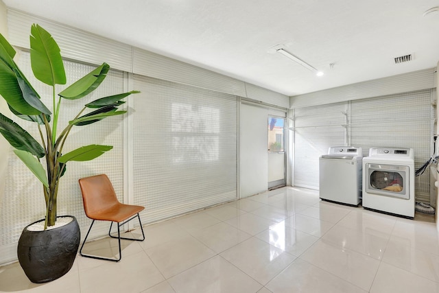 laundry area with light tile patterned floors and independent washer and dryer