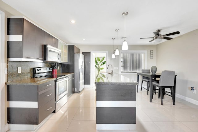 kitchen with pendant lighting, ceiling fan, light tile patterned floors, tasteful backsplash, and stainless steel appliances