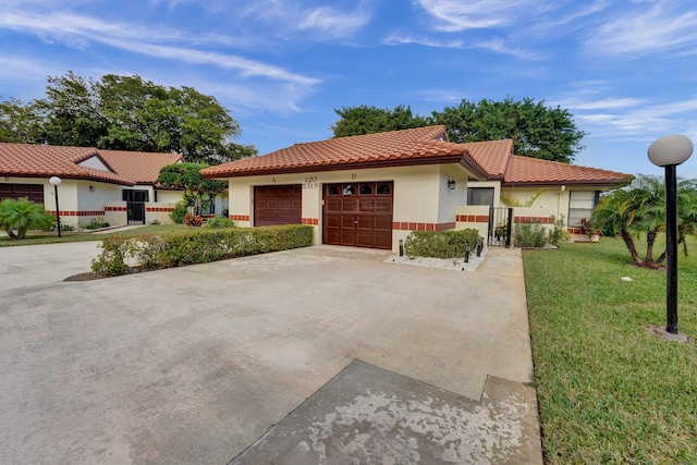 mediterranean / spanish-style home with a front yard and a garage