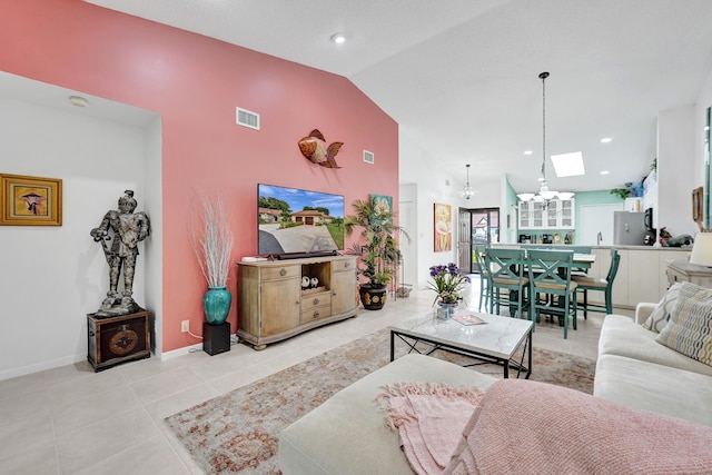 living room with a notable chandelier, a skylight, high vaulted ceiling, and light tile patterned flooring