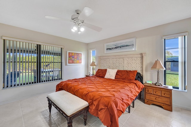 bedroom featuring multiple windows, light tile patterned flooring, and ceiling fan