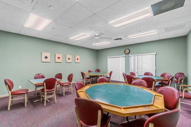 recreation room with ceiling fan, a paneled ceiling, and carpet flooring