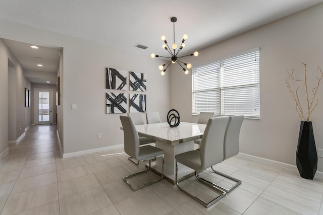 tiled dining space featuring a notable chandelier and a textured ceiling