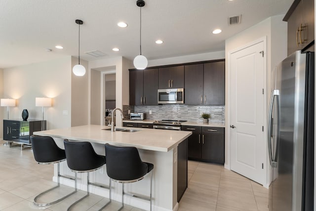 kitchen with sink, decorative light fixtures, dark brown cabinets, and appliances with stainless steel finishes