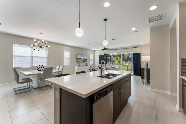 kitchen with dark brown cabinetry, sink, stainless steel dishwasher, an island with sink, and pendant lighting