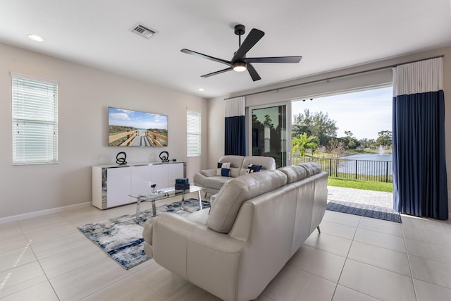 tiled living room with ceiling fan and a healthy amount of sunlight