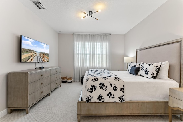 bedroom featuring light carpet and a textured ceiling