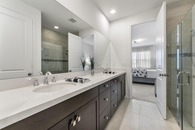 bathroom featuring tile patterned floors, vanity, and a shower with shower door