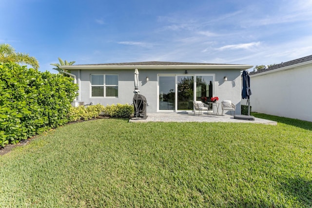 rear view of property featuring a patio area and a lawn