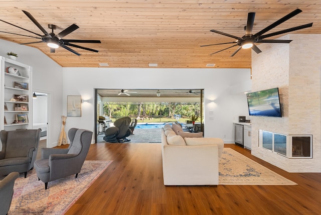 living room featuring lofted ceiling, wood ceiling, wood-type flooring, and a stone fireplace