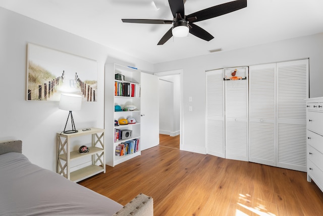 bedroom with wood-type flooring, ceiling fan, and a closet