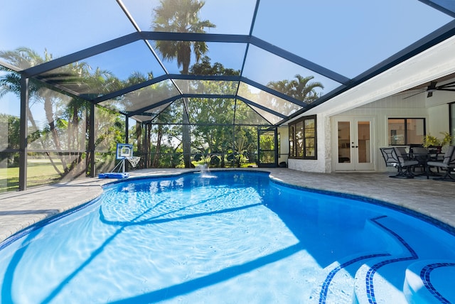 view of pool with ceiling fan, glass enclosure, a patio area, french doors, and pool water feature